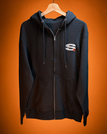Black hoodie with a Secret Anime Club icon logo on a hanger against an orange background